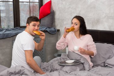 Genç çifti mutlu sadece kruvasan yemek uyandım ve brea sahip