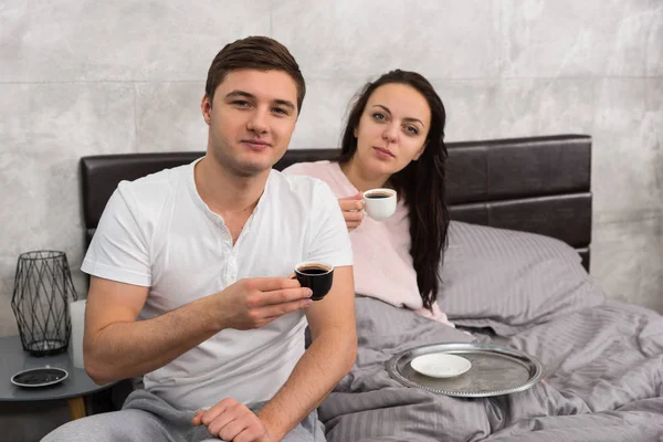 Attraktives Paar gerade aufgewacht, mit einer Tasse Kaffee und hav — Stockfoto