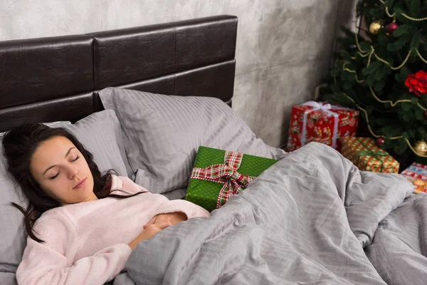 Joven hermosa mujer durmiendo en la cama y Navidad presente lyin — Foto de Stock