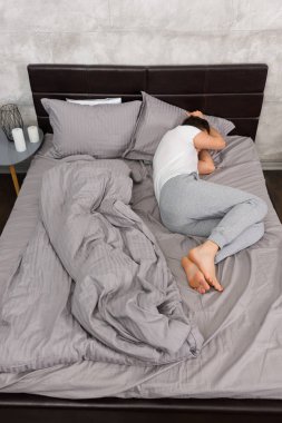 Yorgun adam şık battaniyeye olmadan uyku pijama içinde