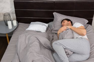 Yakışıklı yorgun erkek pijama yalnız battaniye uyku ve