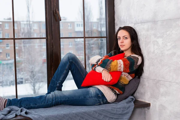 Ung attraktiv kvinna liggande på fönsterbrädan kramas en pi — Stockfoto