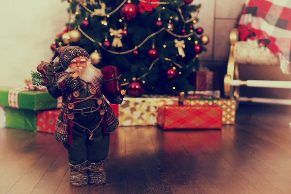 Bonita boneca Papai Noel vestindo traje tradicional e segurando um — Fotografia de Stock