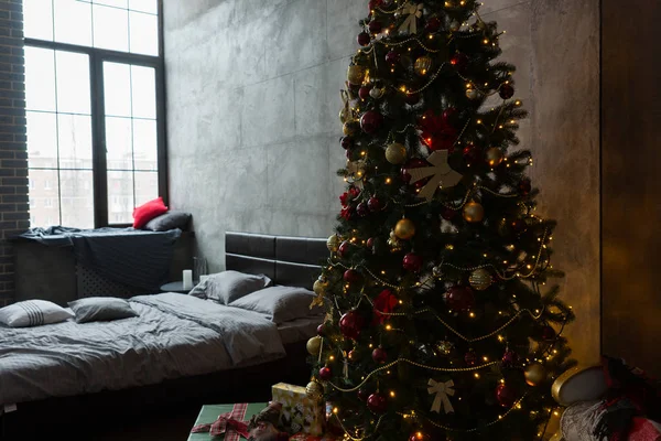 Elegante camera da letto con letto moderno e grande albero di Natale con — Foto Stock