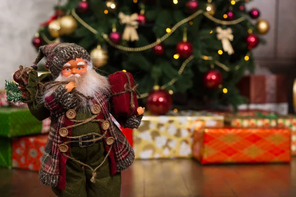 Boneca Papai Noel vestindo traje tradicional e segurando um presente — Fotografia de Stock