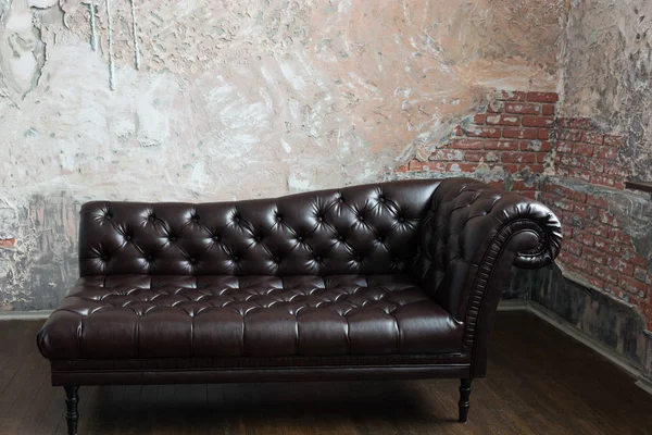 在英国样式与旧砖沃尔玛房间里的真皮沙发 — 图库照片