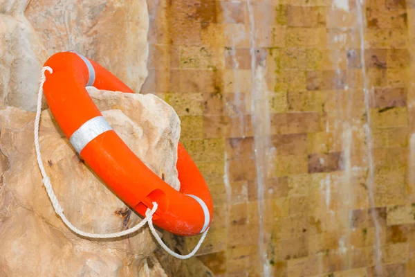 Lifebuoy is on the rock near the waterfall — Stock Photo, Image