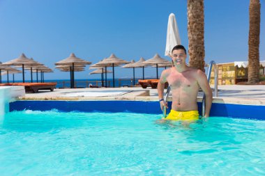 Kameraya bakarak ve gülümseyen genç yakışıklı mutlu adam süre