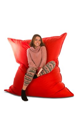 Yaşam için kırmızı puf koltuk sandalye üzerinde oturan gülümseyen genç kadın