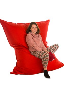 Oturma ro için kırmızı puf koltuk sandalye üzerinde oturan sevimli genç kadın