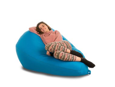 Güzel genç kadın mavi puf koltuk üzerinde yalan 