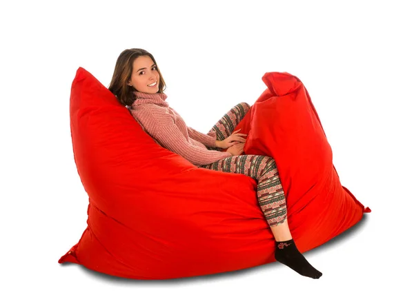 Üzerinde izole kırmızı puf koltuk sandalye üzerinde oturan sevimli genç kadın — Stok fotoğraf