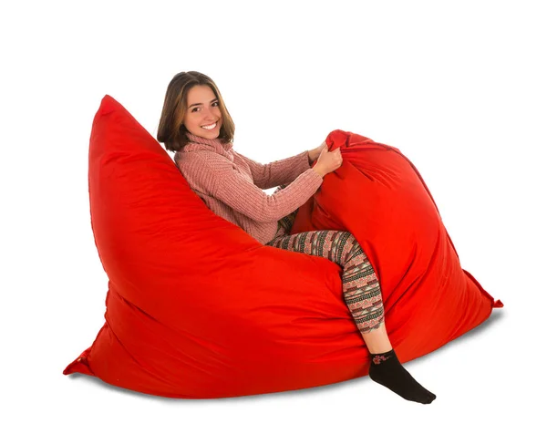 Divertida joven sentada en la silla de sofá beanbag rojo aislado en —  Fotos de Stock