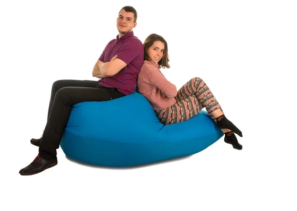 Jovem atraente homem e mulher sentado no azul beanbag sofá isol — Fotografia de Stock