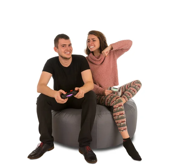 Jonge man en vrouw spelen van videospellen zittend op ronde s — Stockfoto