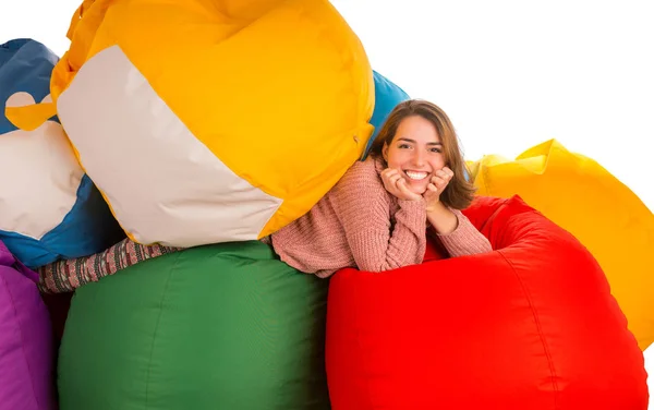 Joven mujer riendo acostada entre sillas de bolsa de frijoles —  Fotos de Stock