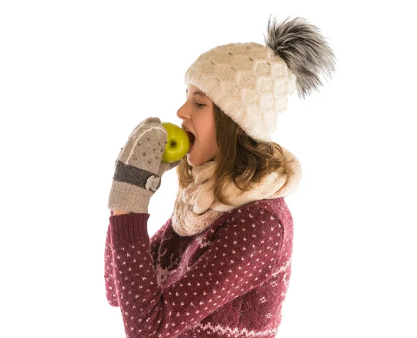 Linda chica en suéter caliente, sombrero, bufanda y manoplas comiendo un appl — Foto de Stock