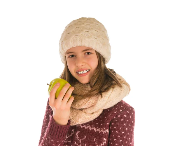 Chica sonriente en suéter caliente, sombrero, bufanda y manoplas comiendo un — Foto de Stock