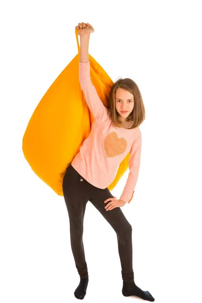 Menina bonito segurando cadeira beanbag amarelo — Fotografia de Stock