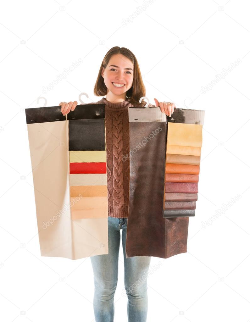 Young woman in sweater holding fabric swatches