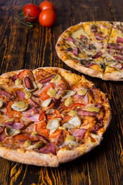 İki lezzetli farklı pizza ile ahşap üzerine Topingler çeşitli ta