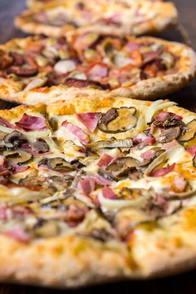 Close up of one of tasty pizzas with variety of toppings and che — Stock Photo, Image