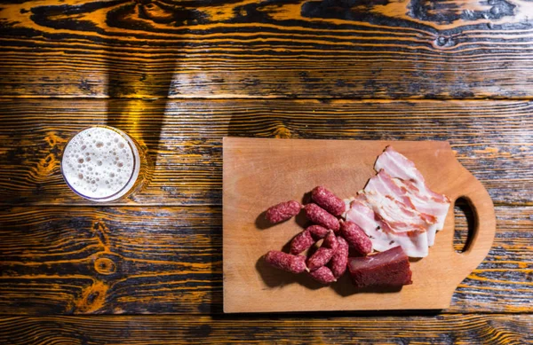 Vista ad alto angolo del tagliere con salsicce e carne vicino a un g — Foto Stock