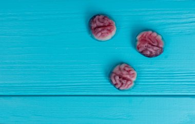 Tasty jelly candies in the shape of a brain on wooden table clipart