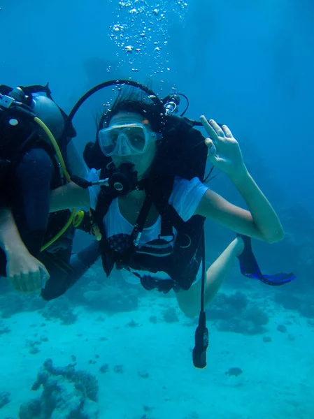Подводная съемка женщины ныряющей и показывающей нормальный сигнал — стоковое фото