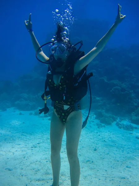 Tiro subaquático de uma mulher mergulhando, coloca as mãos para cima e mostrar — Fotografia de Stock