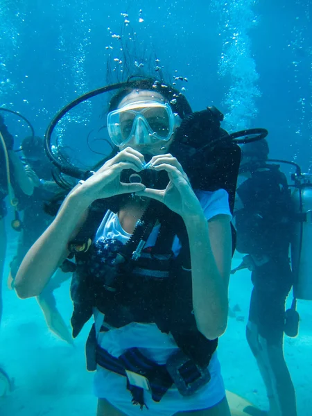 Podvodní natáčení ženy potápění a ukazovat lásku signál — Stock fotografie