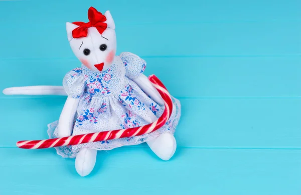 Homemade toy in the form of a cat in a dress holding candy cane — Stock Photo, Image