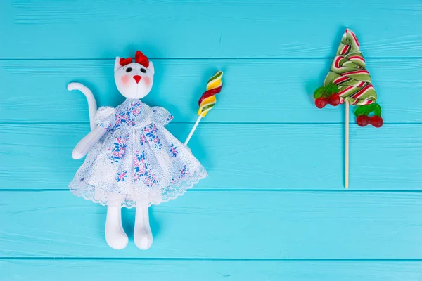 Homemade toy in the form of a cat holding colorful candy near lo — Stock Photo, Image