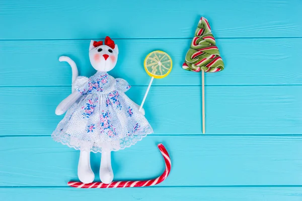 Hausgemachtes Spielzeug in Form einer Katze im Kleid auf dem Bonbonschlitten — Stockfoto