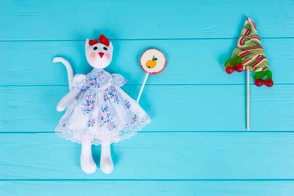 Homemade toy in the form of a cat holding candy near lollipop as — Stock Photo, Image