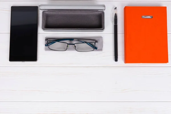 Diario con un bolígrafo, gafas con estilo y estuche abierto para gafas cerca — Foto de Stock