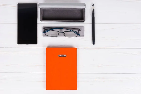 Narancssárga napló tollal, elegáns szemüveg és nyitott ügy üveg — Stock Fotó