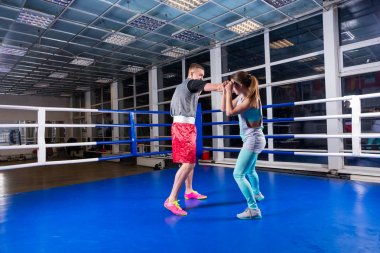 Athletic male and female in sportswear practicing boxing in regu clipart