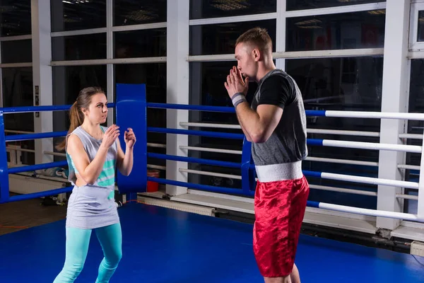 Casal desportivo praticando boxe em um ringue de boxe — Fotografia de Stock