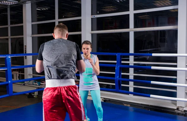 Pareja deportiva en acción practicando boxeo en el ring de boxeo regular — Foto de Stock