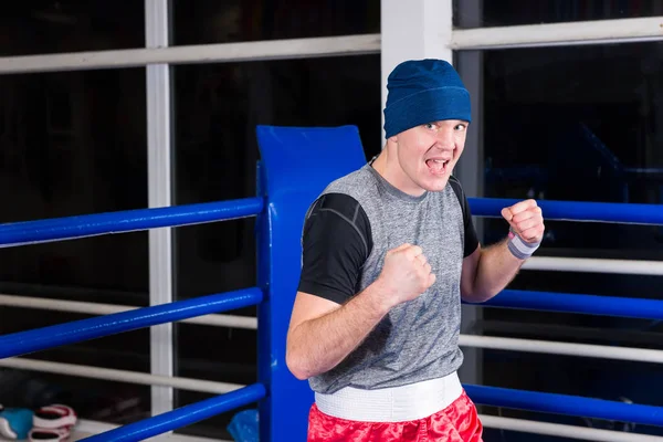Athletischer junger Boxer, der in einer Pose steht, die Fäuste ballt — Stockfoto