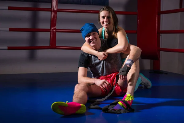 Atletisk kvinna stöd och krama sin pojkvän i en boxningsring — Stockfoto