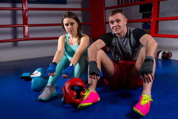 Casal de boxe sentado perto de luvas de boxe e capacete — Fotografia de Stock