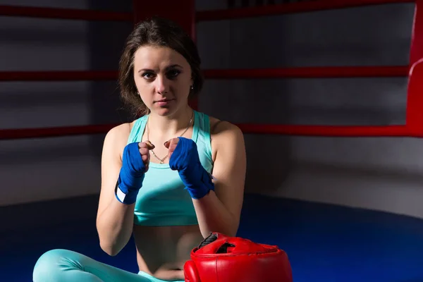 Atletisk kvinnliga boxare sitter och knyter hennes knytnävar — Stockfoto