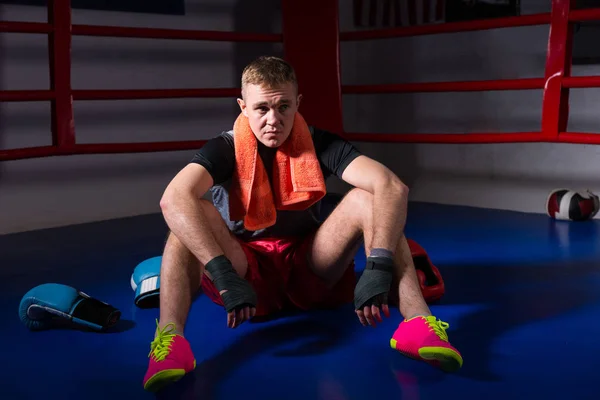 Boxeur masculin avec une serviette autour du cou assis dans la boxe régulière — Photo