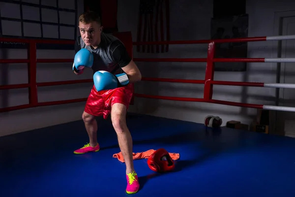 Joven boxeador deportivo masculino en guantes de boxeo se levanta y se prepara para — Foto de Stock