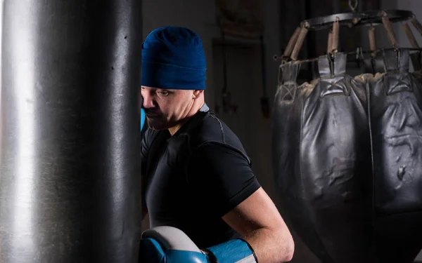 Male boxer with stern look in a hat and boxing gloves training w — Stock Photo, Image