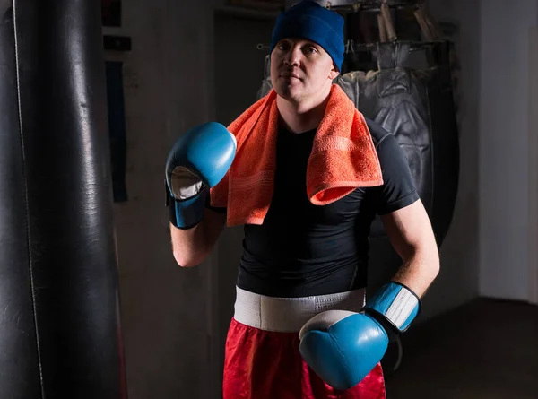 Мужской боксер с полотенцем на шее в шляпе и боксерском шаре — стоковое фото
