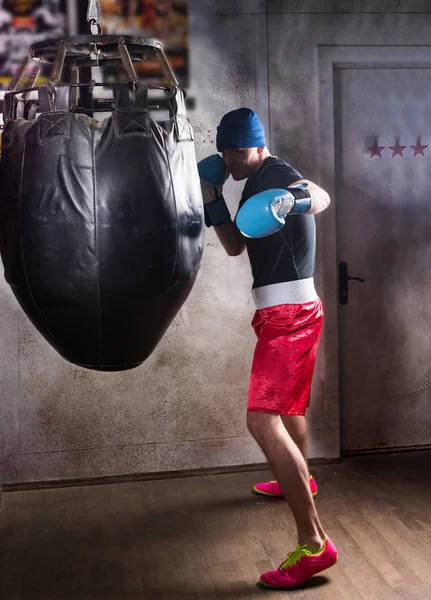 Ung manlig boxare i boxning handskar utbildning med boxning stansning — Stockfoto