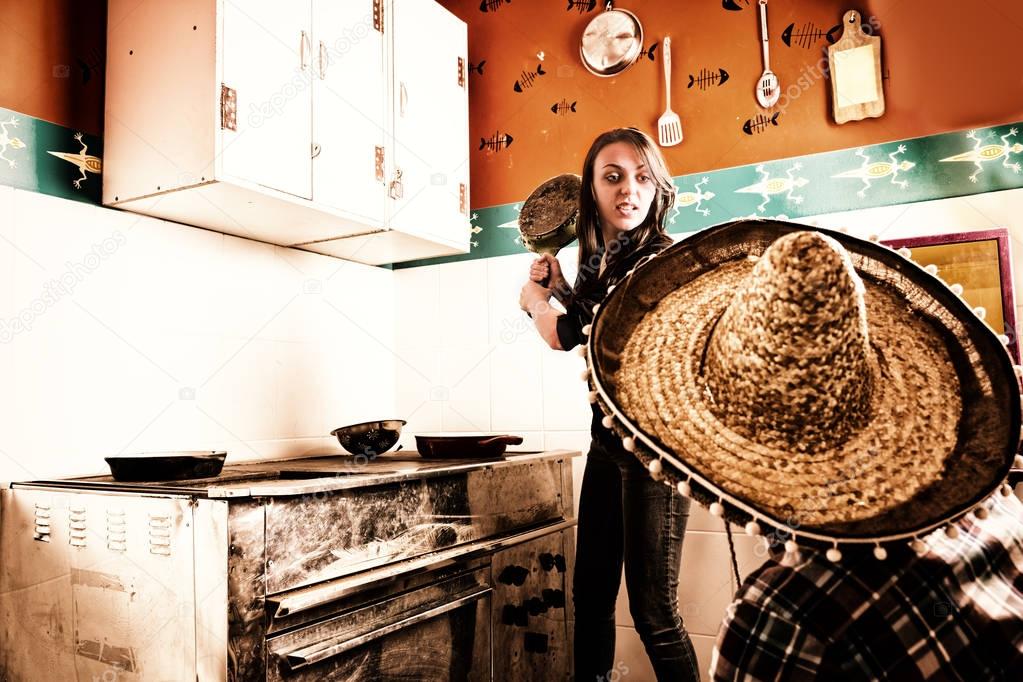 Young angry woman brandishing a frying pan at a man in sombrero